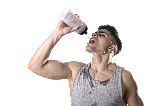 运动员喝水拿着瓶子倒在出汗的脸上图片下载