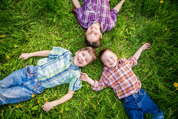 三个孩子在蒲公英的草地上图片下载