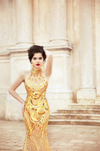 穿着金色连衣裙的时装模特。美丽性感的黑发在优雅图片下载