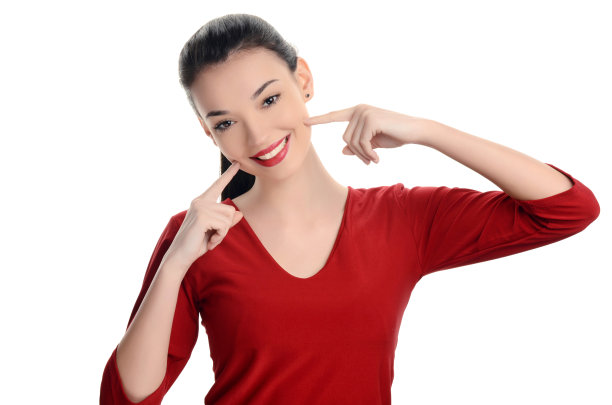 美丽的女孩微笑。快乐的女孩指着她美丽的笑容。图片下载