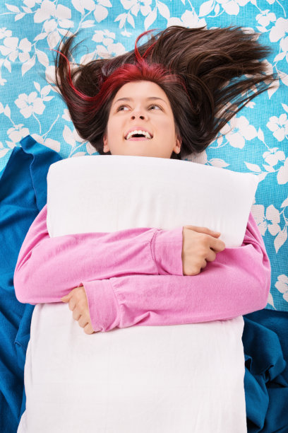 小女孩躺在床上，抱着一个枕头图片下载