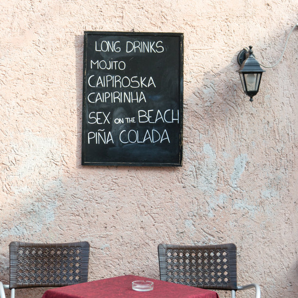 墙上挂着的黑板上有一张酒水单图片下载