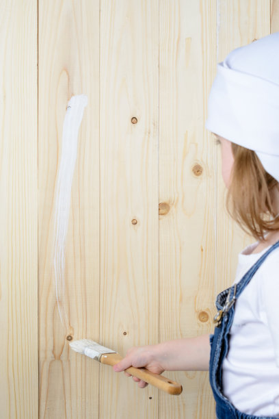 小女孩画一堵木墙图片下载