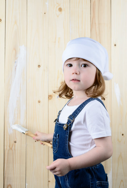 小女孩画一堵木墙图片下载