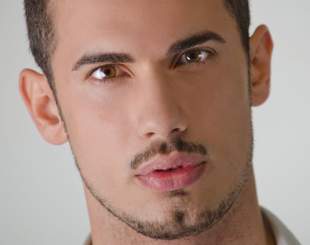 一个年轻的帅哥看着相机的大头照图片下载