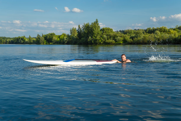 年轻有吸引力的男子游泳与站立桨板图片下载