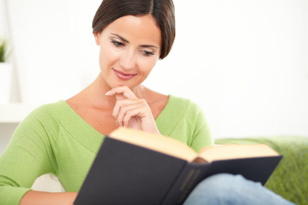 美丽的女人一边看书一边思考图片下载