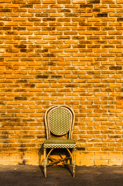 旧砖墙附近的老式木椅图片下载