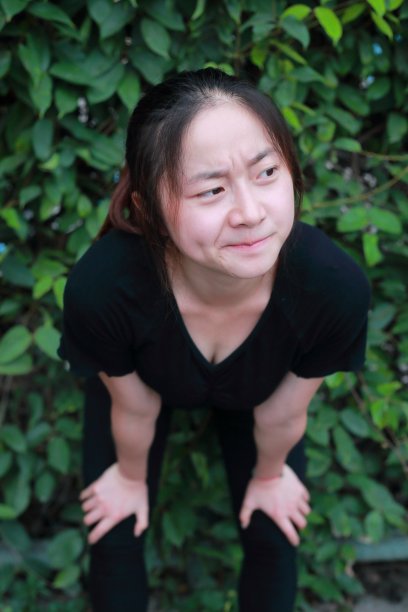 女孩在绿色的墙上做鬼脸图片下载