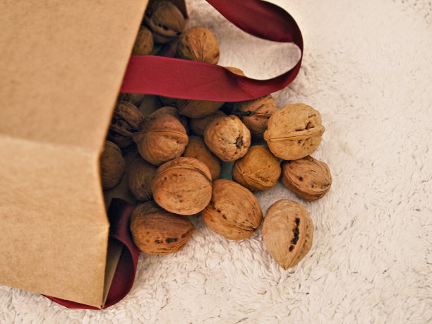 帆布上散落着纸袋里的核桃。图片下载