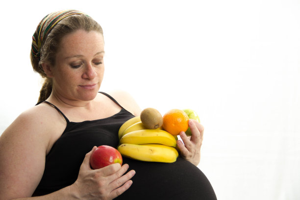 孕妇吃水果孤立的白色背景图片下载