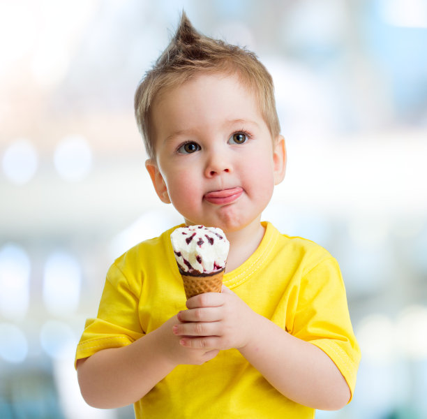 模糊背景下的搞笑小孩在吃冰淇淋图片下载
