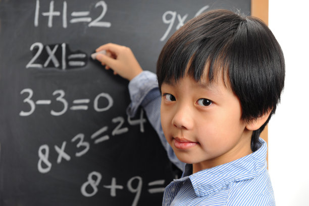 聪明的亚洲男孩在黑板上写字图片下载
