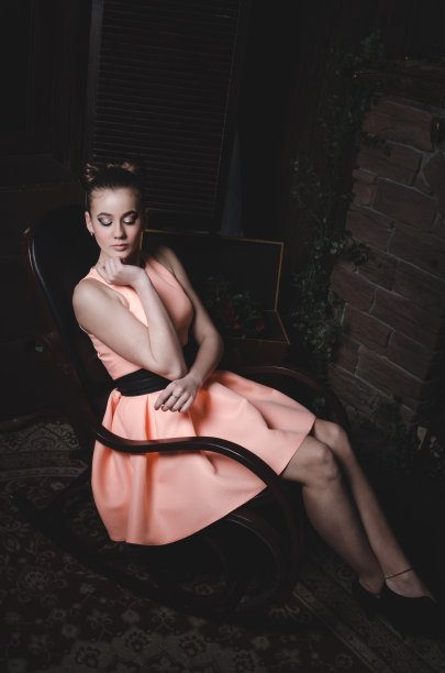 时尚迷人的年轻女子坐在黑暗的房间里。漂亮的女图片下载