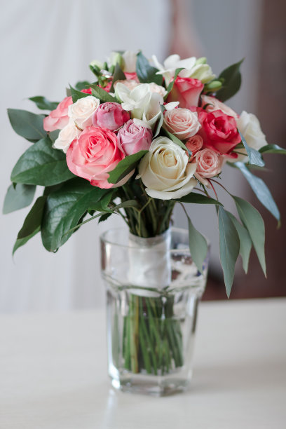 新娘花束放在木桌上的玻璃杯里图片下载