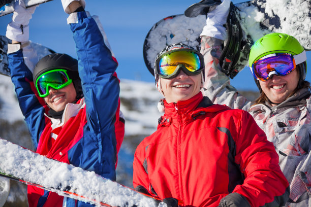 三个朋友拿着滑雪板和天空图片下载