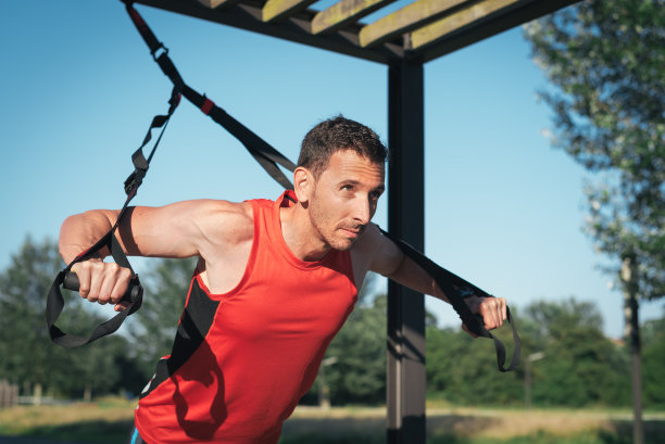 男人用trx健身带做俯卧撑训练手臂图片下载