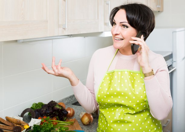 一个穿着围裙的家庭主妇在打电话图片下载