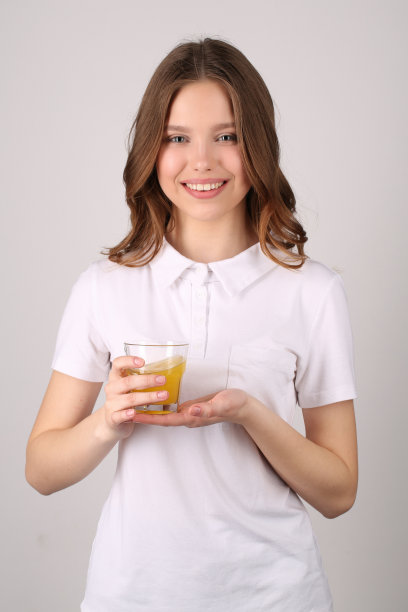拿着果汁摆姿势的模特。关闭了。白色背景图片下载