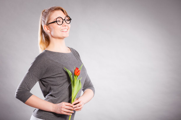 快乐的金发女人与春天的花。图片下载