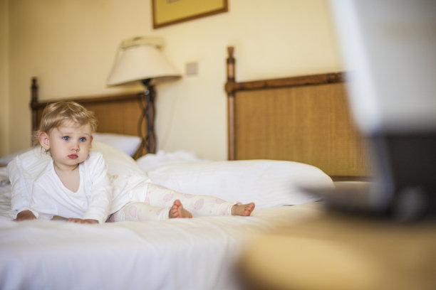 漂亮的小孩在床上看着诺布科图片下载
