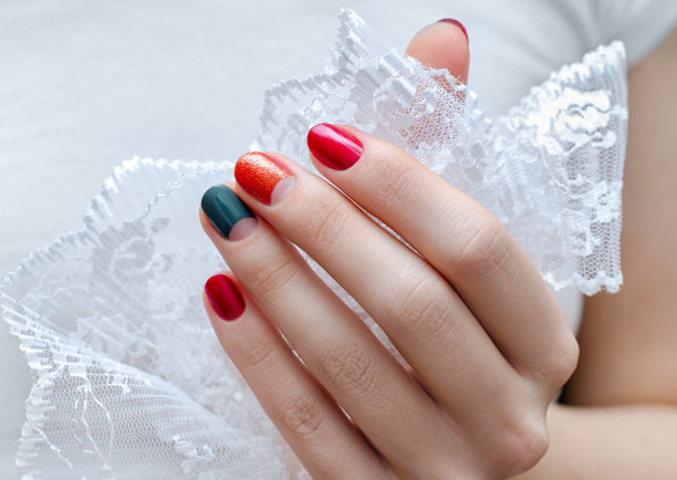 女性的手有红色和绿色的指甲设计图片下载