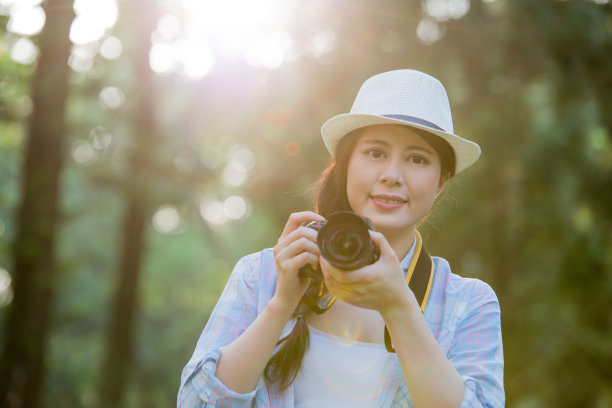 美丽的亚洲女孩微笑着用数码相机拍照，图片下载