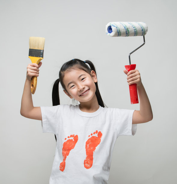 可爱的亚洲女孩拿着画笔和油漆滚筒图片下载