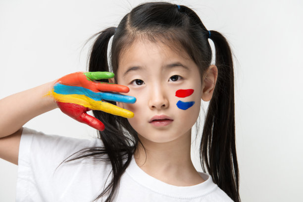 一个亚洲小女孩，手上涂着彩色颜料图片下载