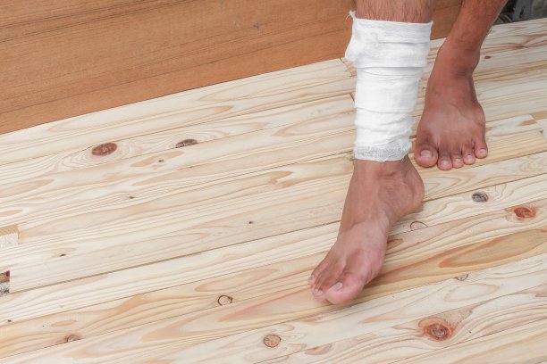 用纱布包扎足部溃疡患者男性正在包扎他的伤口图片下载