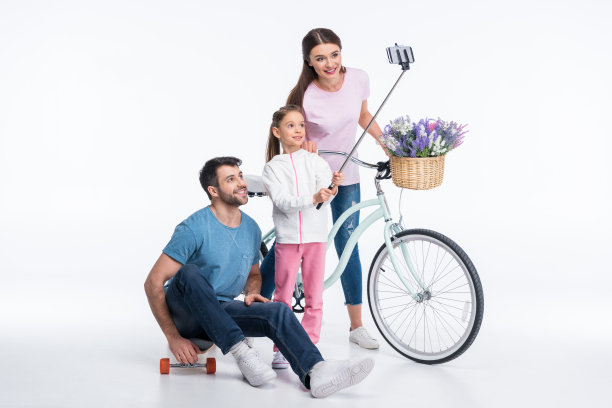 幸福的家庭与滑板和自行车在白色上自拍图片下载