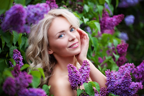 水疗模特女人与健康的皮肤和金色的头发在鲜花背景。春季美容，面部护理和美容概念图片下载