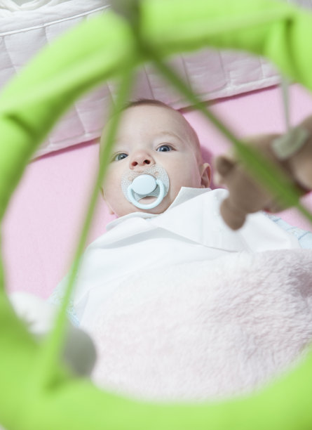 小男孩躺在白色的小床上图片下载