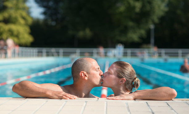 一对情侣在泳池里接吻图片下载