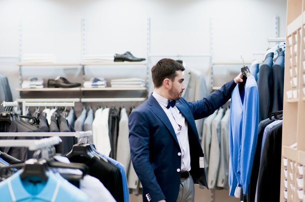 一个男人在精品店买t恤。图片下载
