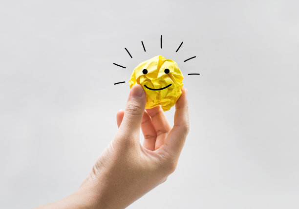 人手上揉成的纸球，上面有商业标志。概念的概念图片下载