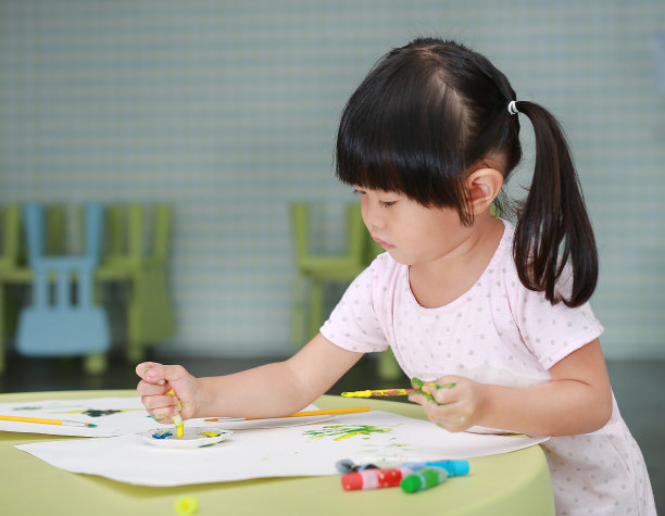 可爱的亚洲儿童女孩用画笔和水彩画。图片下载