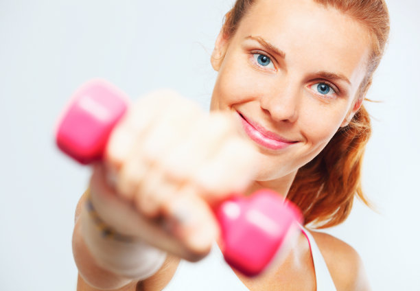 一个手里拿着哑铃的年轻女人。图片下载