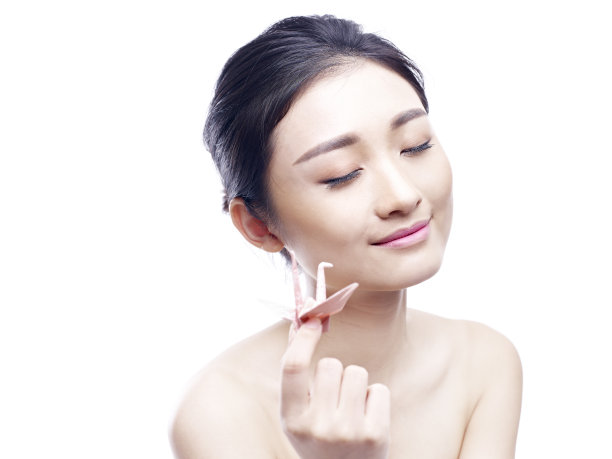 一位年轻的亚洲女子手持纸鹤素材图片