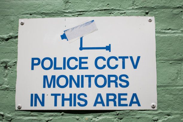 绿色墙上的闭路电视警告标志图片下载