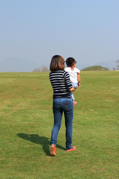 妈妈抱着女儿在公园里散步图片下载