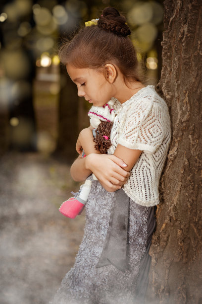 可爱的小女孩和洋娃娃在森林里图片下载