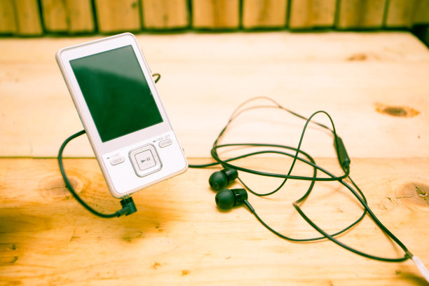mp3播放器和耳机放在木桌上图片下载