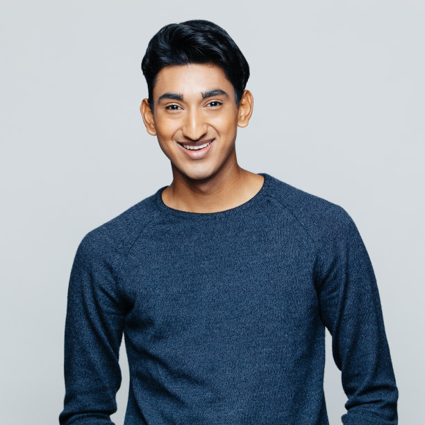 灰色背景前微笑的年轻人图片下载