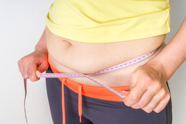 超重妇女用卷尺量肚子上的脂肪图片下载
