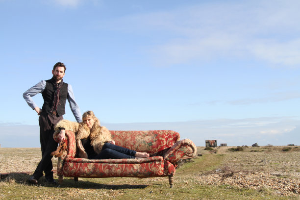 和一对迷人的情侣在沙滩上的沙发上图片下载