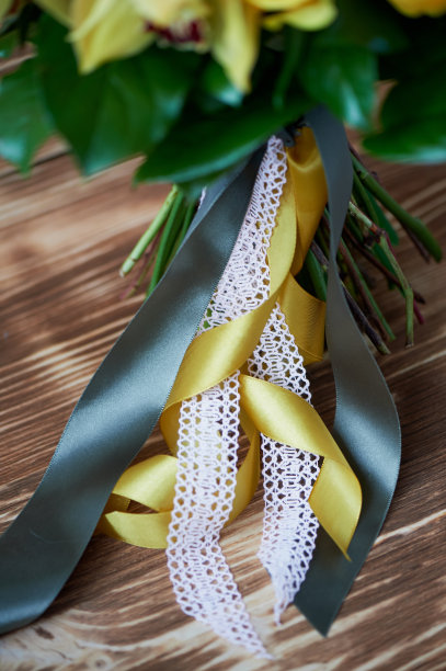 花束的腿，用绿黄相间的缎带和花边系好。关闭图片下载
