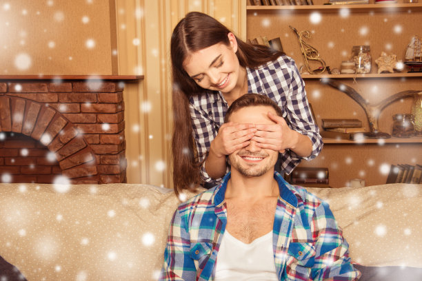 快乐的女孩用手捂着男友的眼睛过圣诞节图片下载