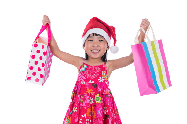 亚洲华人小女孩戴着圣诞老人帽和购物袋图片下载