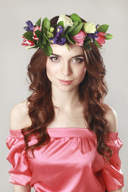 温柔浪漫的女孩，头上戴着玫瑰花环，穿着粉红色的衣服。快乐的春天女人。穿着粉红色长裙的夏天女士图片下载